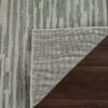 Corner of rug folded on wooden floor.