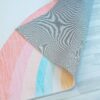 Colorful rug corner on wooden floor.