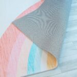 Colorful rug corner on wooden floor.