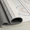 Rolled geometric-pattern rug on wooden floor