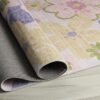 Folded floral pastel rug on wooden floor.
