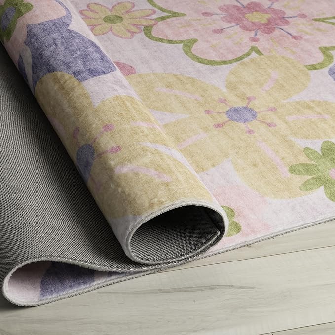Folded floral pastel rug on wooden floor.