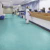 Hospital reception area with people at the desk.