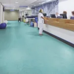 Hospital reception area with people at the desk.