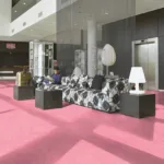 Modern lobby with pink floor and floral couch.