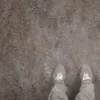 Person wearing gray shoes on brown floor