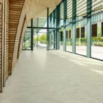 Modern building hallway with wooden arch and glass walls.