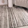 Striped gray rug on light wooden floor.