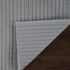 Gray woven rug on dark wood floor.