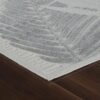 Beige rug with abstract leaf pattern on wood floor.