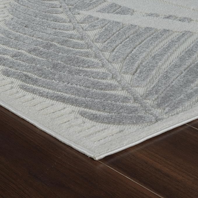 Beige rug with abstract leaf pattern on wood floor.