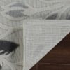 Gray floral rug corner on wooden floor