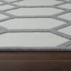 Gray geometric patterned rug on wooden floor.