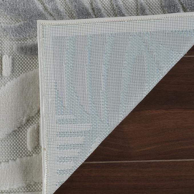 Gray rug corner flipped on wooden floor.