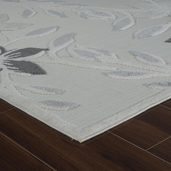 Textured floral area rug on dark wood floor.