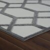Gray and white geometric rug on wooden floor.