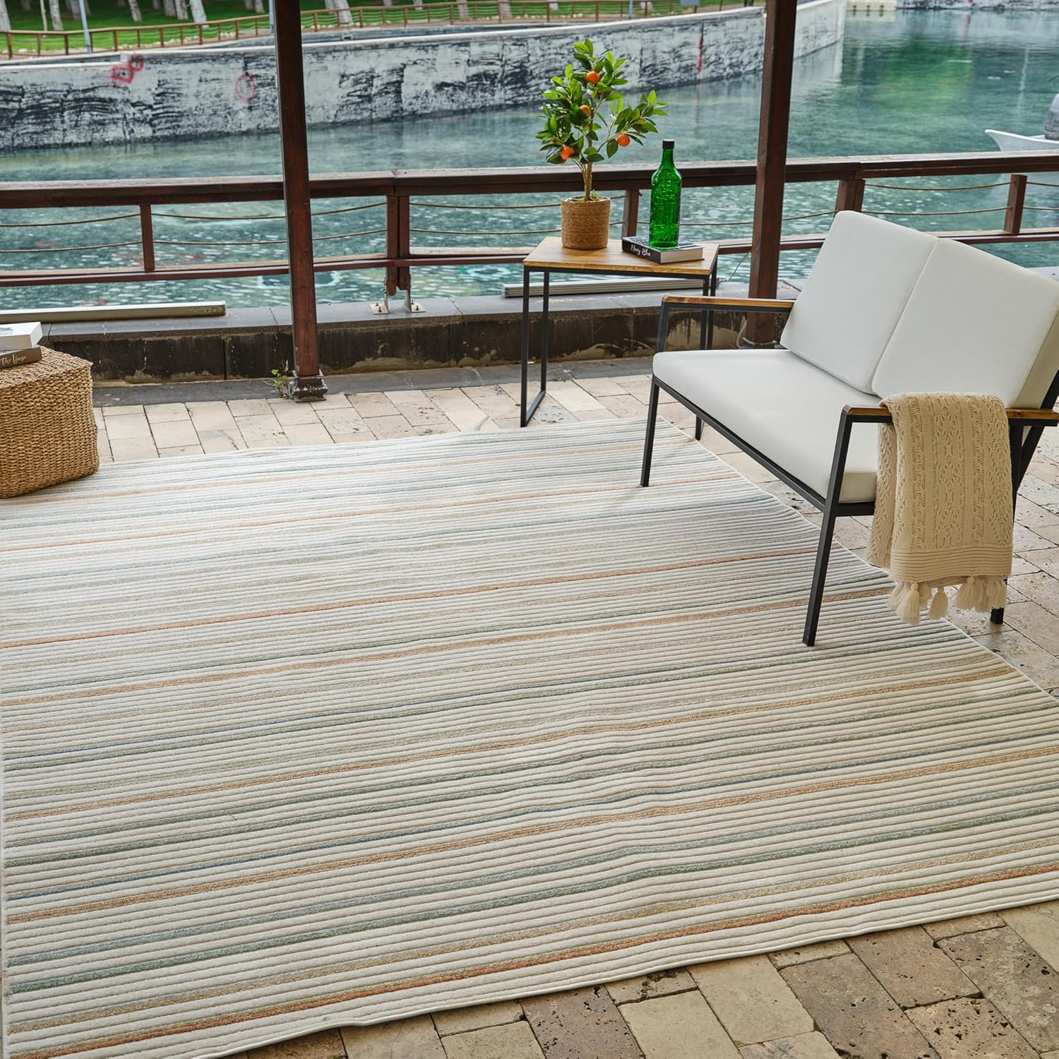 Outdoor rug on patio with chair and table.