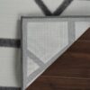 Folded corner of a gray patterned rug
