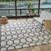 Geometric outdoor rug in a patio setting by water.