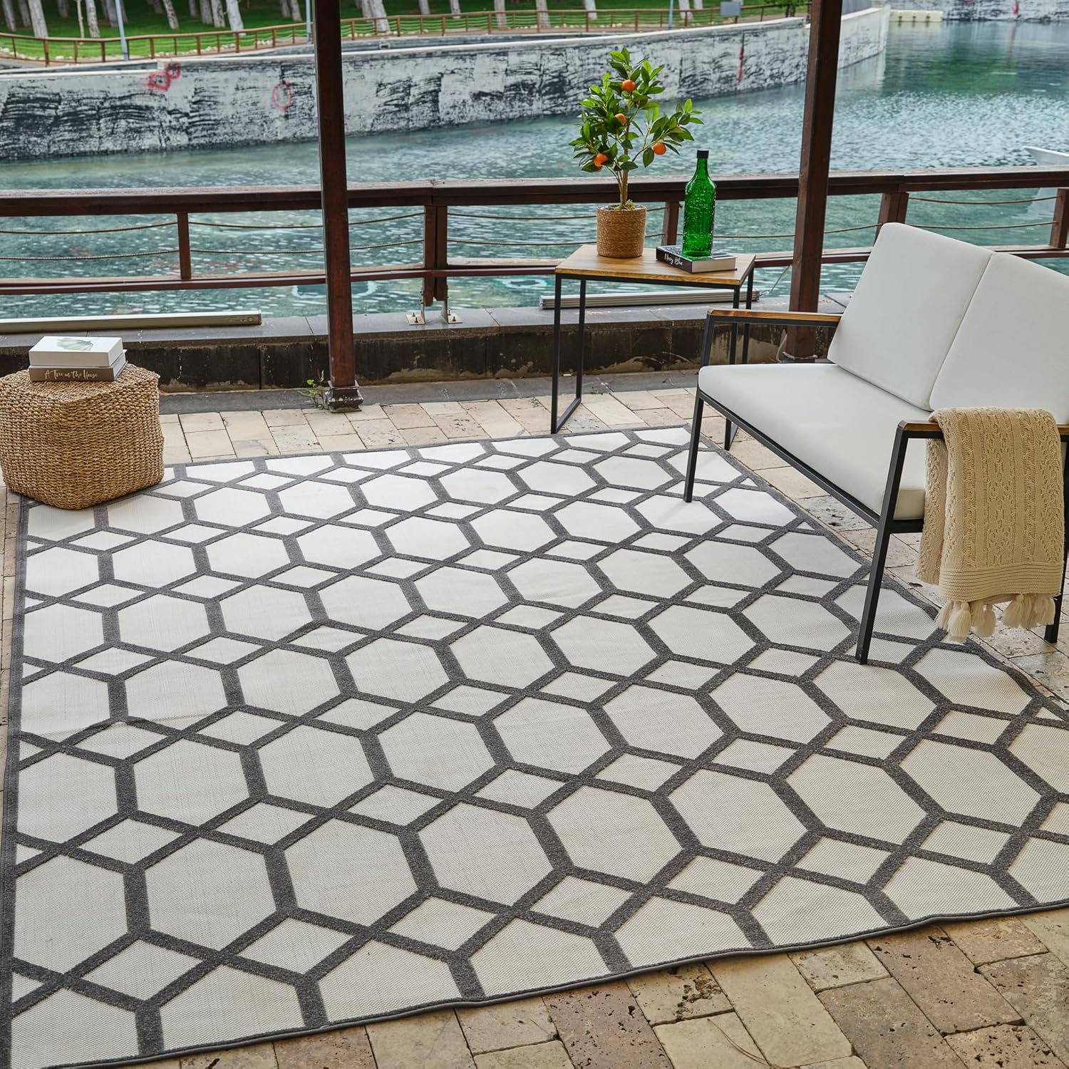 Geometric outdoor rug in a patio setting by water.