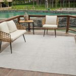 Outdoor patio with chairs and a Buddha statue.