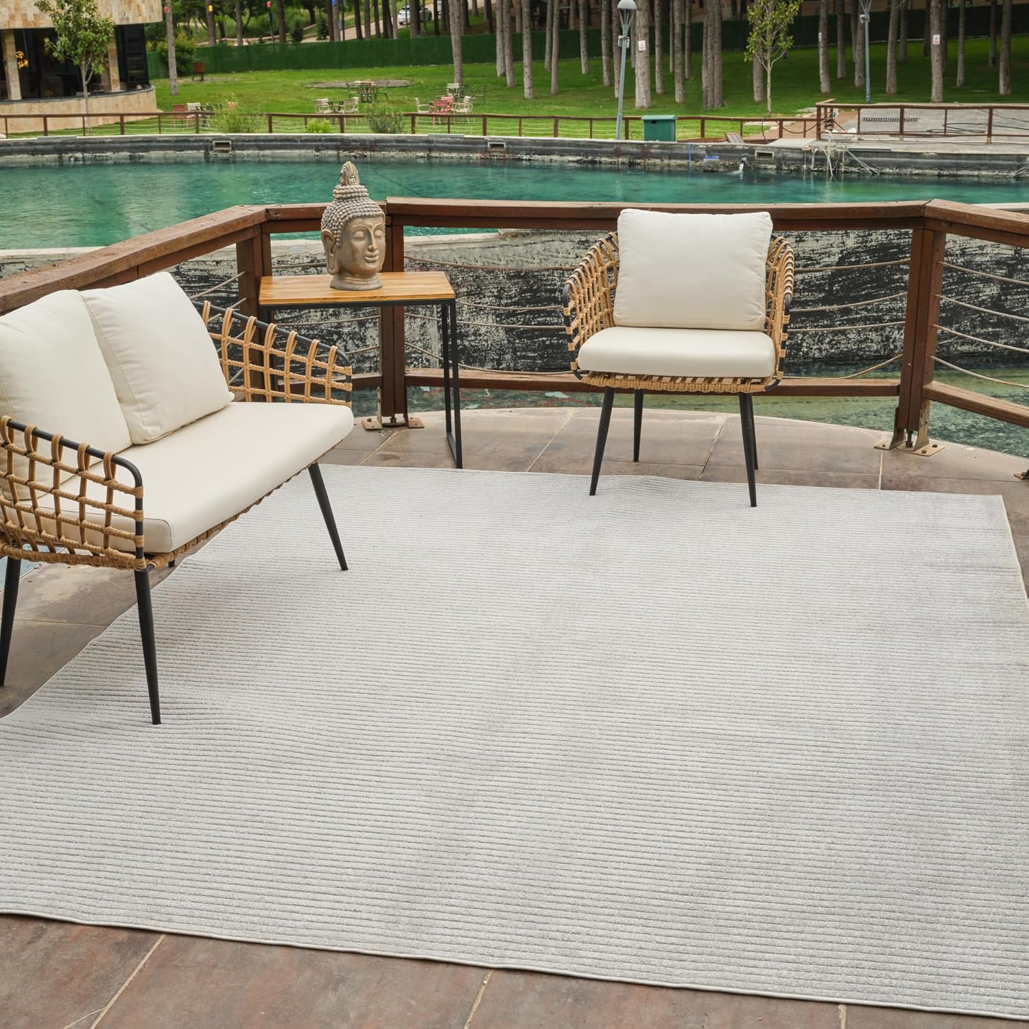 Outdoor patio with chairs and a Buddha statue.
