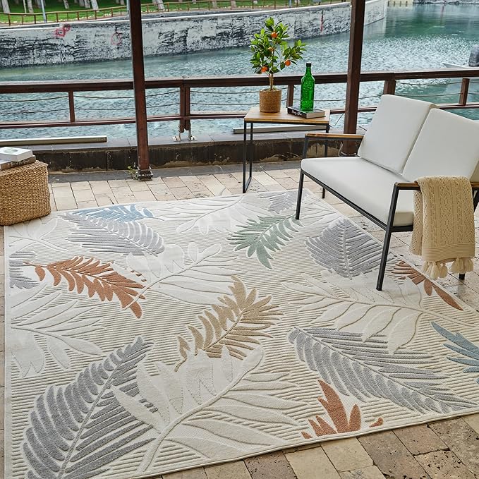 Outdoor patio with leaf-patterned rug and seating.