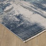 Blue and beige abstract rug on wooden floor