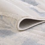 Close-up of folded beige gray area rug