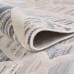 Close-up of folded patterned rug corner.