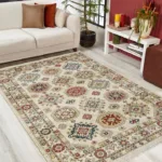 Living room with patterned area rug, sofa, and plants.