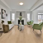 Modern living room with green chairs and fireplace.