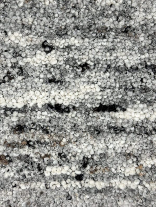 Close-up of textured gray and white carpet fibers.