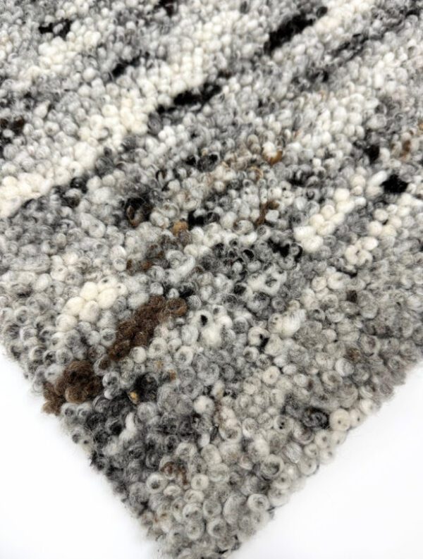 Close-up of textured gray and white rug corner