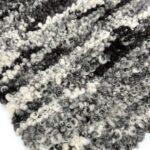 Close-up of curly black and white wool texture.