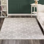 Gray patterned rug on wooden floor in living room.