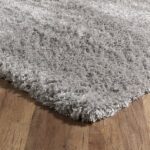 Gray shaggy rug on wooden floor