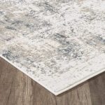 Beige and gray patterned rug on wooden floor.