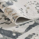 Close-up of a patterned beige and gray rug.