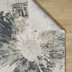 Abstract sunburst pattern rug on wooden floor.