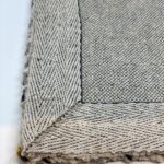 Close-up of woven fabric corner, gray and beige.