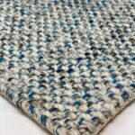 Close-up of textured woven rug with blue accents.