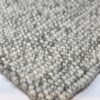 Close-up of gray textured carpet corner.
