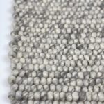 Close-up of woven wool carpet texture.