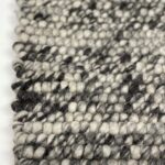 Close-up of textured black and white woven rug.