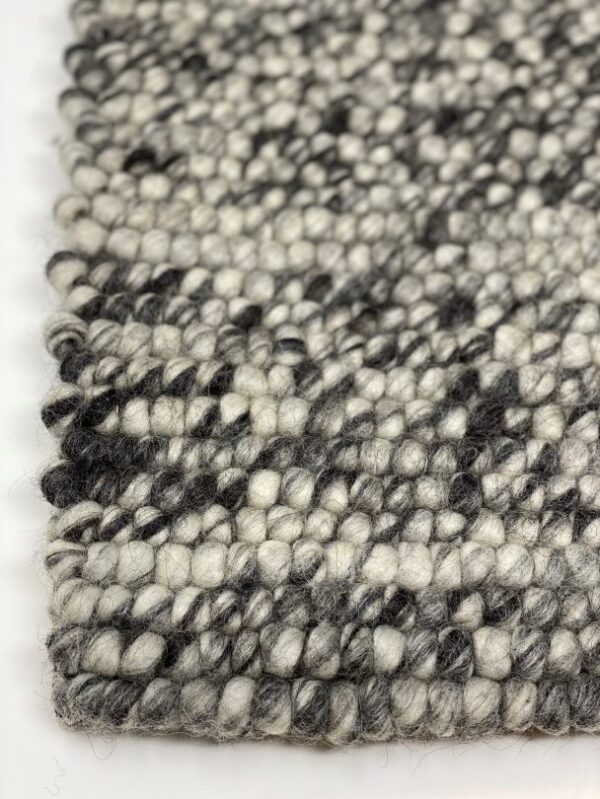 Close-up of textured black and white woven rug.