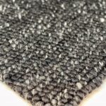 Close-up of woven gray textured rug corner.