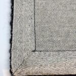 Close-up of textured gray woven fabric with edges