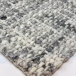 Close-up of gray woven wool rug texture.