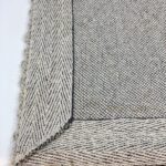 Close-up of beige woven fabric corner detail.